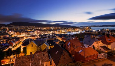 Bergen 'in çatıları gün batımında gökyüzünden gökyüzüne yükseliyor, Norveç