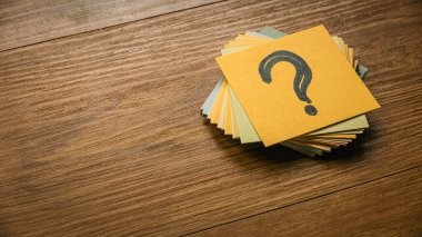 Sorular ve cevaplar konsepti. Üzerinde soru sembolü olan bir kağıt yığını..