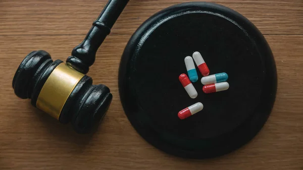 Drugs, medical,Pharmaceuticals and law concept. Gavel and pills on a wooden desk.