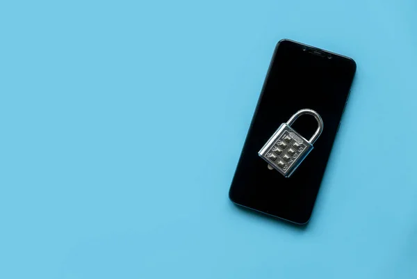 Mobile phone security concept. Data and privacy. Padlock over a smartphone on a blue background. Copy space,