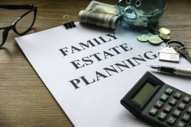 Aile mirası planlaması. Emlak yatırımı ve ev ipoteği finansal emlak konsepti. Belge, para, hesap makinesi, gözlük ve anahtar ahşap masada..