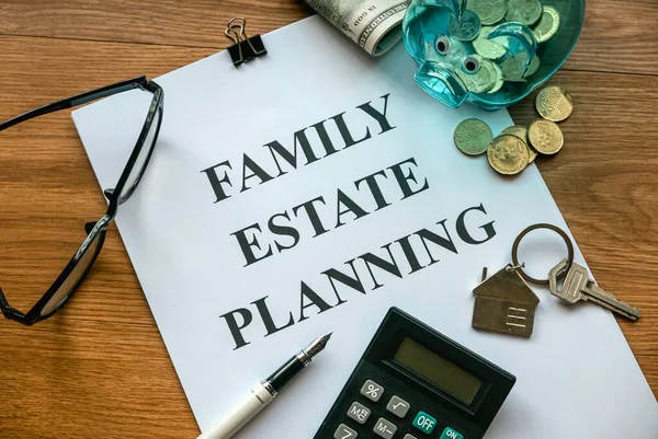 Family estate planning. Property investment and house mortgage financial real estate concept. Document, money, calculator, glasses and key on wooden table.