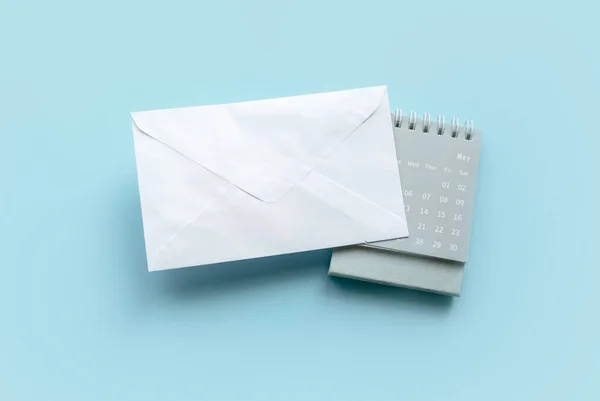 Een Witte Envelop Een Kalender Een Blauwe Achtergrond — Stockfoto