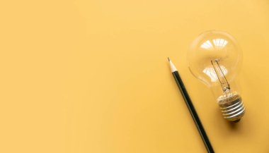 Yaratıcı düşünce, yenilik ve ilham konsepti. Sarı arka planda ampul. Boşluğu kopyala.