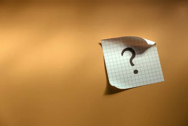 Questions and answer concept. Question mark written on paper. Brown silhouette shadow background.