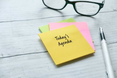 Kalem ve renkli not defterinin ahşap zemin üzerinde kopya alanı ile Today 's Agenda ile yazılmış üst görünümü