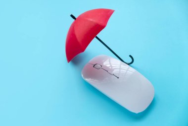 Bilgisayar ve ağ güvenliği kavramı. Bir bilgisayar faresinin üzerinde kırmızı şemsiye.