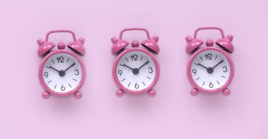 Pembe zemin üzerinde pembe alarm saati.