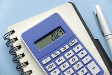 Concept of new year finance, inflation, recession, tax, budget and cost of living. Financial reminder of fiscal year 2024. 2024 on calculator screen.	