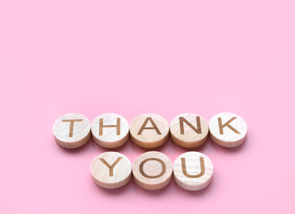 Alphabet word thank you on pink backgroun with copy space.