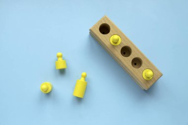 Eğitici oyuncaklar, bilişsel beceriler, çocuk gelişimi mantıklı düşünme konsepti. Montessori ahşabı oyuncakları mavi bir arkaplan üzerinde şekillendirir. Farklı şekil ve boyutlarda ayırır..