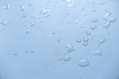 Yaratıcı poster tasarımı için mavi bir arkaplan üzerine su damlıyor.