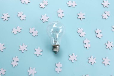 Dağıtılmış Yapboz Parçaları Mavi Arkaplana Karşı Ortadaki Ampul