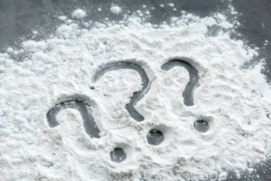 Question mark symbol written on a flour powder. clipart