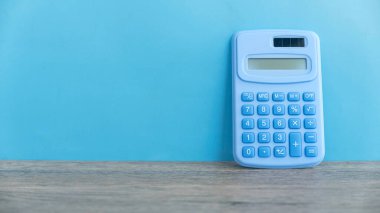 Kopya alanı olan mavi bir duvara karşı hesap makinesi.