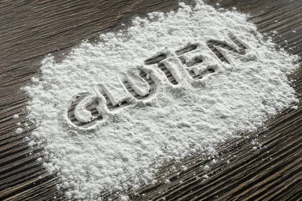 Masaya serpilmiş un tozu üzerine yazılmış glüten..