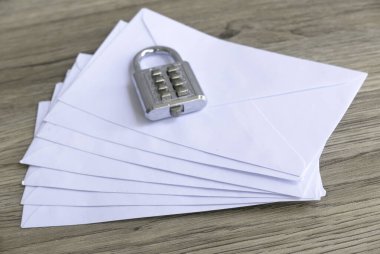 Protecting Correspondence: A Padlock on a Stack of White Envelopes clipart