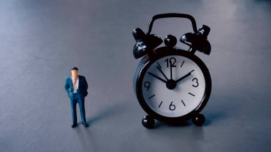 Alarm Saatinin Yanında Duran İşadamı Zaman Yönetimi, Dakiklik ve İş Teslim Tarihi Kavramını Temsil Ediyor