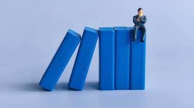 Domino etkisi ile Mavi Bloklarda oturan Minyatür İşadamı