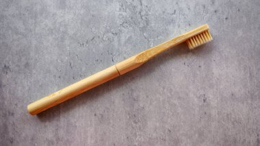 Dokulu Gri Arkaplan Üzerinde Seyahat Çantası olan Doğal Bambu Diş fırçası