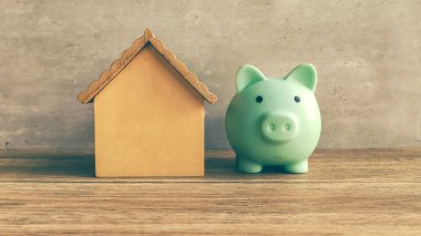 Piggy Bank and Wooden House Model Symbolize Saving Money for a Home or Real Estate Investment