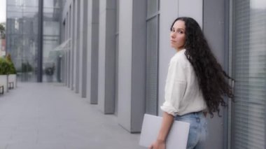 İş kadını, işçi, patron, serbest çalışan, yönetici, profesyonel, ofise gidiyor, şehir merkezine yakın bir yere gidiyor, bilgisayar laptopuyla kameraya gülümsüyor.