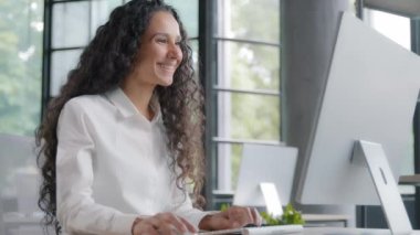 Modern ofis bilgisayarında çalışan başarılı bir iş kadını. E-postaları kontrol eden genç iş kadını. İyi haber okuyan.