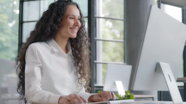 現代のオフィスでコンピュータ上で働く幸せな成功したビジネス女性若いビジネス女性は 電子メールをチェック良いニュースを読んでオンラインストアで注文する満足した女性の顧客は笑顔カメラを見て — ストック動画