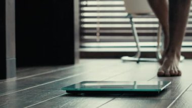 Yakın çekim erkek ayakları elektronik dijital ölçekte durur bilinmeyen erkek sporcu sporcu kilo kaybı kontrolü tanınmayan adam spor salonunda egzersiz yapıyor kalori obezitesi anoreksiyonu