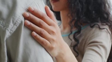 Yakından bir kadın eli erkeğin omzunda sarılma desteğine uzanır. Tanımlanamayan kıvırcık kadın kucaklaşması dokunaklı kocayı desteklemeye yardımcı olur evli çift birbirine sarılır