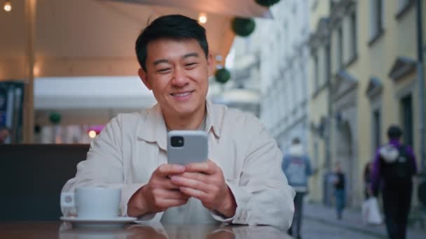 Улыбающийся Азиат Турист Сидит Уличном Кафе Держа Руках Билеты Мобильный — стоковое видео