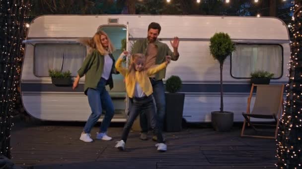 白种人快乐快乐快乐无忧无虑的家庭成年父母带着女学生晚上在靠近面包车的营地跳舞庆祝旅行派对跳着歌舞升腾 — 图库视频影像