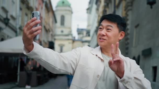 Joyful Adult Male Tourist Holding Smartphone Looking Screen Taking Pictures — Stock Video