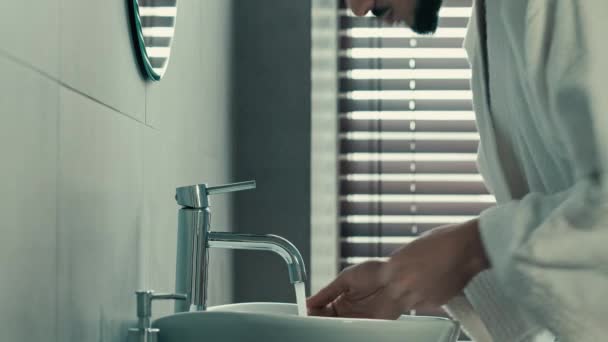 옆에는 아메리카 출신의 수염을 남자가 욕조에서 아침에 목욕을 싱크대 근처에서 — 비디오