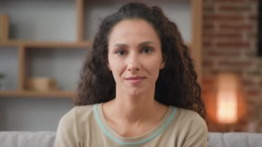 Evdeki kapalı portreyi kapat. Kıvırcık saçlı, beyaz, Latin bir kadın. 30 'lu yaşlarda mükemmel ciltli bir İspanyol kadın. Bayan müşteri müşteri öğretmen ev sahibi kameraya bakıyor.