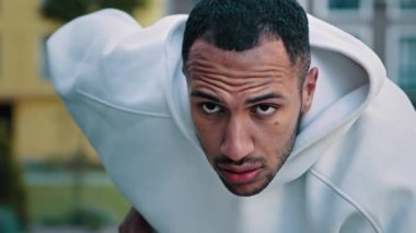 Motive olmuş genç erkek koşucu Latin koşucu koşucu koşucu koşucu koşucu koşucu sporcu koşucu sporcu şampiyon mesafe koşusu için hazır şehir yolunda eğilmiş vaziyette oturarak spor koşusu için hazırlanıyor maraton koşusu yapıyor.