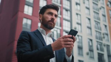 Kafkas sakallı girişimci işadamı cep telefonu mesajlaşma standı tutuyor modern ofis binaları ile birlikte cep telefonu telefon aramalarında mobil iş uygulaması haberlerini kullanıyor