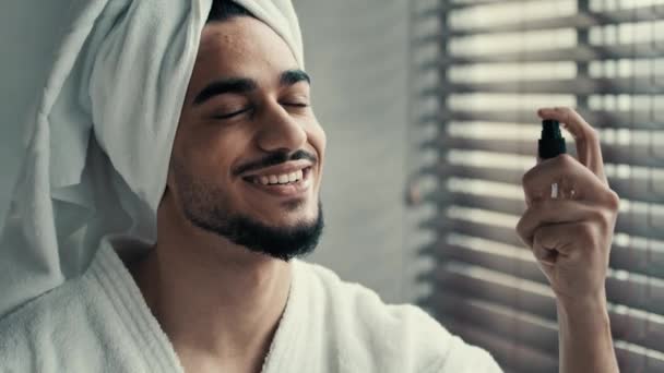 有趣的家伙漂亮的男性程序 西班牙裔拉美裔男子头戴毛巾洗澡时喷涂面部液体化妆品完美护肤止痛抗皱水合面雾喷雾 — 图库视频影像