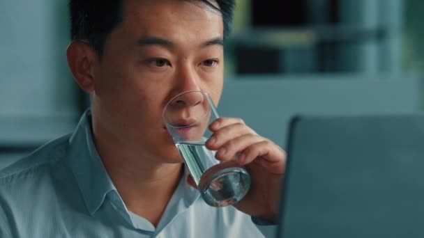 アジアの中年韓国人男性労働者のビジネスマンは オフィスで働くコンピュータ上のオンライン電子商取引は冷たい新鮮な水の渇きの一時飲みガラスを作る健康水分補給のバランスを保つ健康的なボディケア — ストック動画