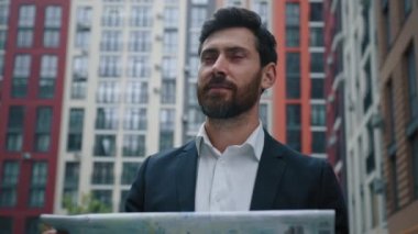 Yurtdışından gelen erkek gezgin işadamı şehir turu için şehir turu yapan şehir haritası kullanıyor. Kağıt harita kullanıyor. Yeni yerel sakallı turist rehberiyle modern ofis merkezini arıyor.