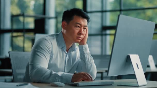 退屈怠惰なアジア人労働者のビジネスマン韓国人日本人男性疲れ男性はオフィスで眠ってコンピュータ開発ビジネスプロジェクトで退屈なオンライン作業から疲れて疲れやる気の不足を感じて — ストック動画
