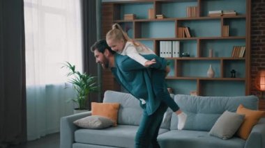 Aktif baba sırtında taşıdığı sırtında küçük kız çocuğu beyaz sağlıklı bir aile çocuk uçak oyununda oynuyor mutlu çocuk tatillerin tadını çıkarıyor evde birlikte eğleniyor.
