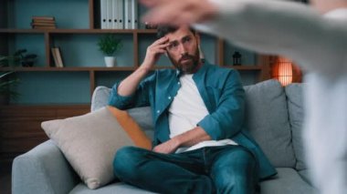 Üzgün baba, evde koşan gürültücü kız yüzünden hayal kırıklığına uğramış bir şekilde kanepede oturur, bağırır, evde oynar gibi bağırır. İtaatsiz, rahatsız edici, çocuk bakımı gerektiren bir babadan rahatsız olur.