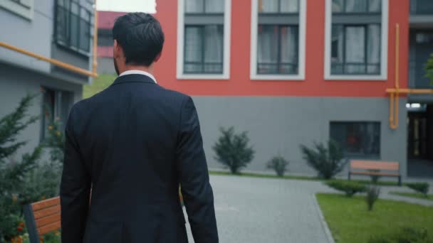 リアビュー大人の自信のあるビジネスマン男性リーダーは オフィス検索への道だけで街を歩く住宅現代的な建物の外観都市中心部のアーキテクチャ — ストック動画