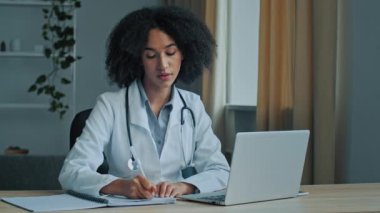 Afrikalı kadın doktor terapist. Klinikte pratisyen hekim. Video görüşmesi yapan bir hastaya danışmanlık yapıyor.
