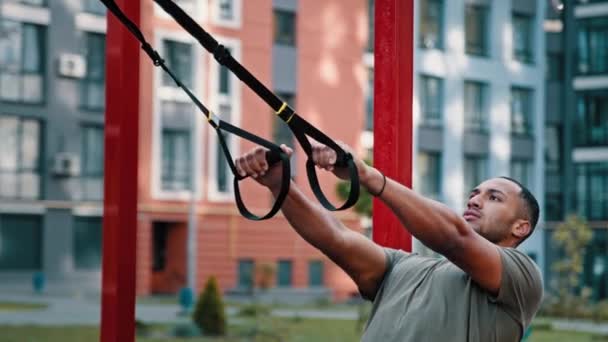 肌肉运动强壮有力的拉蒂诺美国男子健美运动员利用体育器材在城市运动场上进行室外伸展运动 用Trx带进行运动 积极健康地生活 — 图库视频影像