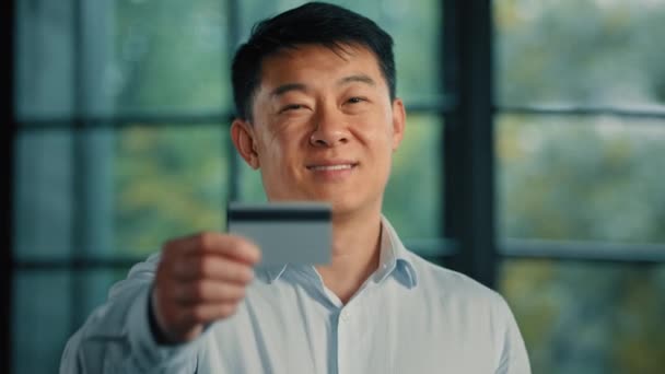 亚裔韩国男子日本男性雇员商人银行服务的投资者客户持有塑料信用卡 存款不受限制 用于网上购物和商业交易 — 图库视频影像