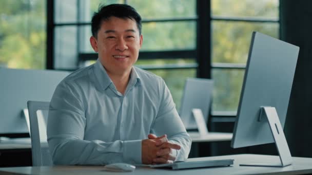 アジア日本人韓国人男性シニアマネージャー40代ビジネスマン労働者ボスチームリーダーは 現代的なビジネス会社のオフィスの場所に座って幸せな成功した自信の男性プロの肖像画 — ストック動画