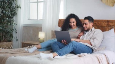Çok ırklı evli çift, etnik sakallı koca karı koca, karı koca internette dizüstü bilgisayara bakıp gülerek internet üzerinden alışveriş yapan karı koca.