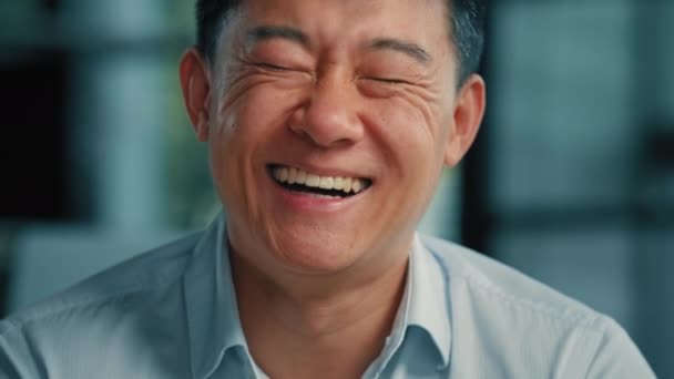 朗らかな笑いアジア系韓国人健康な男40代の大人の男性の肖像幸せな感情的なおもちゃ笑顔日本の民族の実業家のクライアントのボス誠実な笑いを楽しみますユーモアのある冗談楽しい気分 — ストック動画